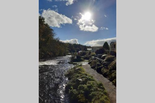 a river with the sun in the sky at Chalet 174 Glan Gwna Park Caernarfon in Caeathro