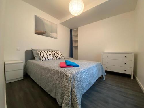 um quarto com uma cama com um cobertor azul e uma cómoda em Vichy Centre ville - Gare - Parc des sources em Vichy