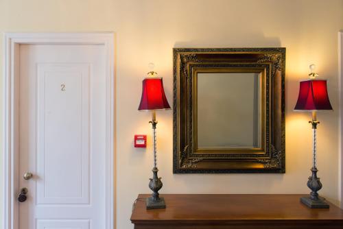 two lamps on a table next to a mirror at Archontiko Argyro in Makrinítsa