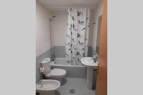 y baño con aseo, lavabo y bañera. en Apartamento Aurora llanes 4 pax, en Posada de Llanes