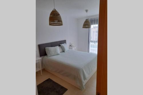1 dormitorio con cama blanca y ventana en Apartamento Aurora llanes 4 pax, en Posada de Llanes