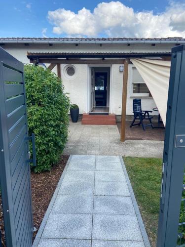 einen Gehweg, der zu einem Haus mit einer Terrasse führt in der Unterkunft Ferienhaus Rohde - Dargun am Waldeck in Dargun