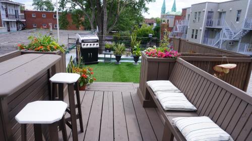 a deck with benches and a table and a grill at HoMa Homestay Hotel by Olympic Stadium Montreal Auberge-Hostel in Montréal