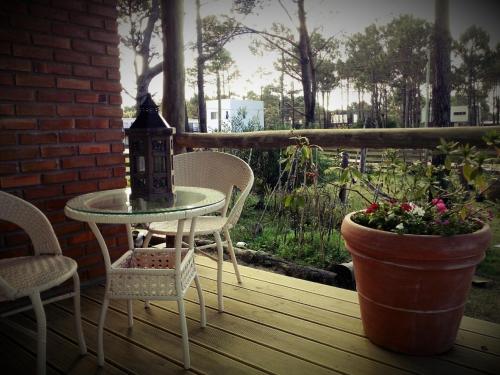 a table and chairs on a porch with a pot of flowers at Il Tano Suites in Punta Del Diablo