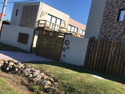 uma casa com um portão de madeira e uma cerca em LAS ESTEÑAS , casas del mar em La Pedrera