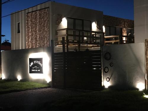 uma casa com um portão à noite com luzes em LAS ESTEÑAS , casas del mar em La Pedrera