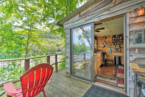 a cabin with a table and a chair on a deck at Adirondack Mountains Cottage Near Gore Mountain! in Warrensburg