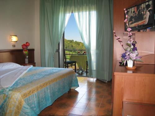 a bedroom with a bed and a view of a balcony at Hotel Boomerang - Check-in & Meals in front at hotel Sporting in Tabiano