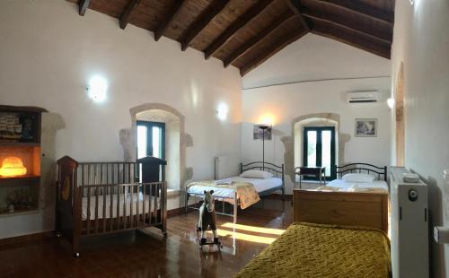 a bedroom with two beds and a crib at Evaggelias Home Gavalochori in Gavalochori