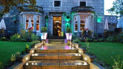 a house with a staircase in front of a building at Great Western Hotel Aberdeen in Aberdeen