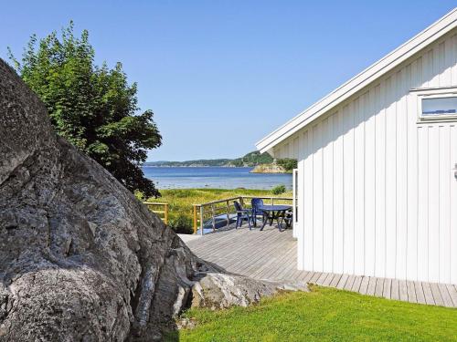 uma grande rocha ao lado de um edifício branco com um pátio em 4 person holiday home in HEN N em Henån