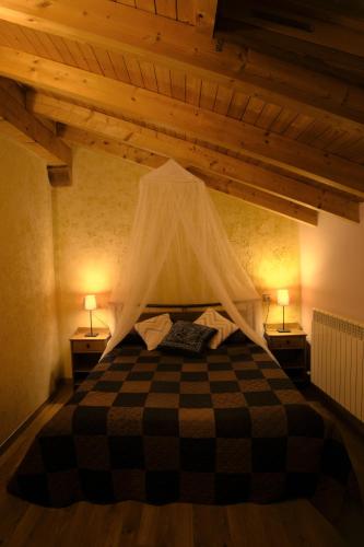 a bedroom with a bed with a mosquito net at Casa Rural La Campana Con o sin Ático in San Millán de la Cogolla