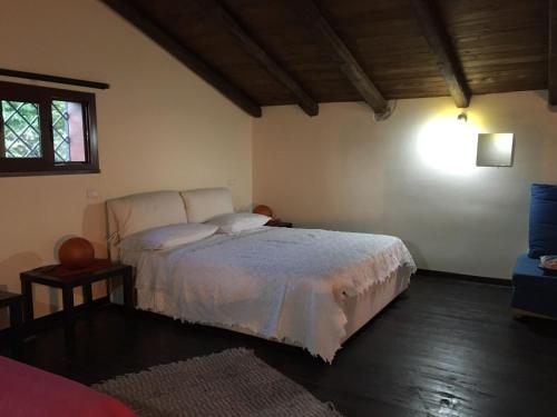 a bedroom with a white bed and a window at Chalet Etna in Biancavilla