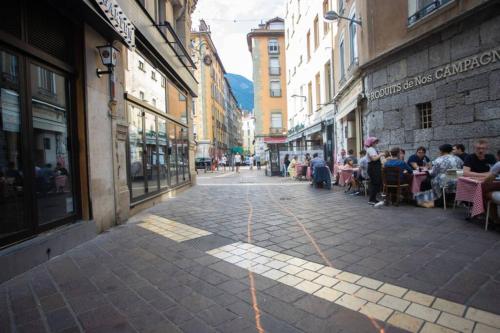 a group of people sitting at tables in an empty street at Le Bohème, Cosy, Hypercentre in Grenoble