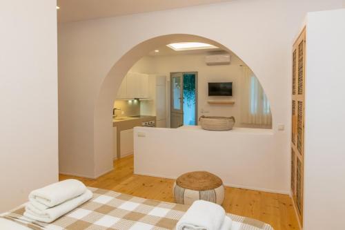 eine Küche mit einem Torbogen in einem Zimmer mit Handtüchern in der Unterkunft Acanthus Houses in Tinos