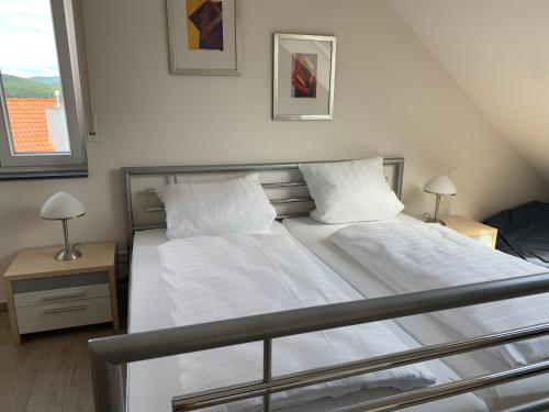 a bedroom with a bed with white sheets and pillows at FreiRaum in Annweiler am Trifels
