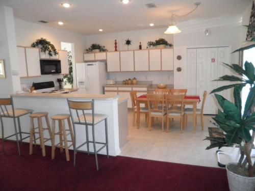 a kitchen and dining room with a counter and chairs at Sunsplash Vacation Homes in Davenport