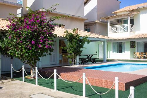 a villa with a swimming pool and a house at Casa das Dunas in Cabo Frio