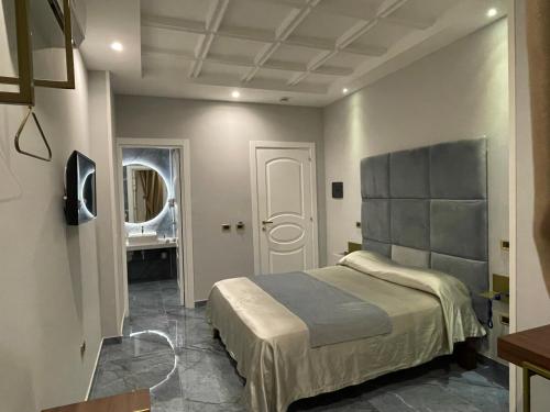 sypialnia z dużym łóżkiem i lustrem w obiekcie Ninfa hotel w mieście Qualiano
