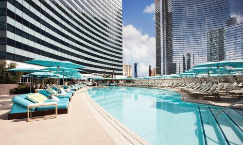 a row of lounge chairs in front of a large building at Vdara Hotel & Spa at ARIA Las Vegas in Las Vegas