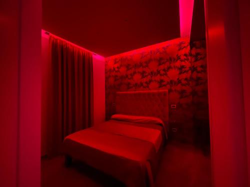 a red room with a bed with red lights at Ninfa hotel in Qualiano