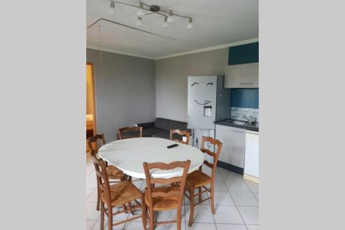une cuisine et une salle à manger avec une table et des chaises dans l'établissement Appartement, à Saint-Bresson