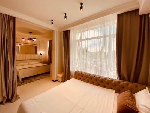 a bedroom with a bed and a large window at DeLight Apartments in Boryspilʼ