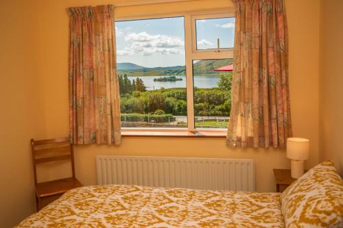 Schlafzimmer mit einem Fenster mit Blick auf das Wasser in der Unterkunft Cottage 390 - Maam in Claggan