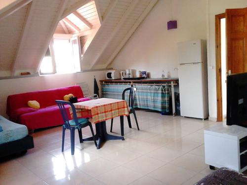 ein Wohnzimmer mit einem Tisch und einem roten Sofa in der Unterkunft STUDIO 2- Laurier - 4 pers - proche centre in Terre-de-Haut