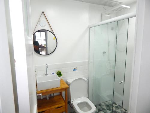 a bathroom with a toilet and a sink and a mirror at Varandas da Praia do Forte - Apartamento frente ao Mar in Cabo Frio