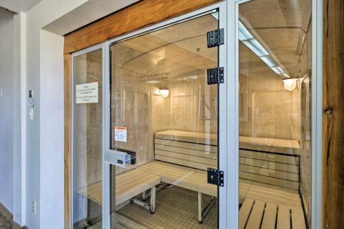 eine Glastür zu einer Zelle mit zwei Bänken im Inneren in der Unterkunft Warm Fraser Townhome with Community Amenities! in Fraser