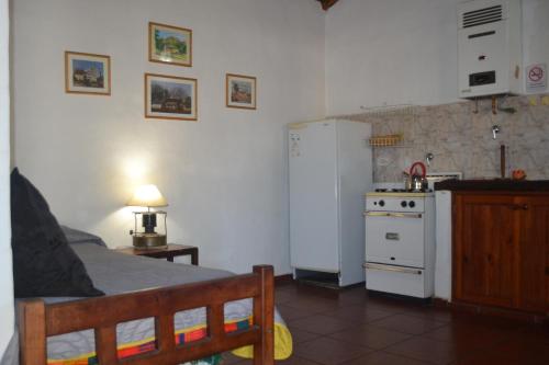 una piccola cucina con un letto e una stufa di Cabañas Los Relinchos a Capilla del Monte