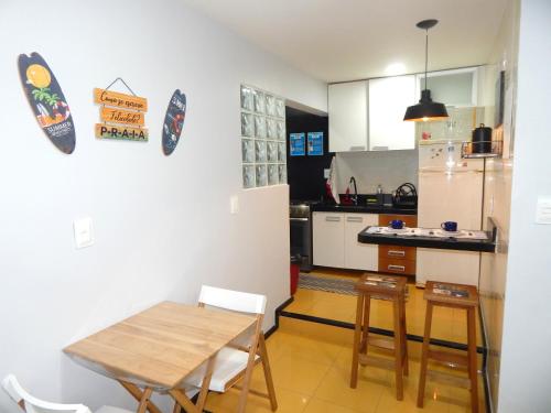 a small kitchen with a wooden table and chairs at Varandas da Praia do Forte - Apartamento frente ao Mar in Cabo Frio