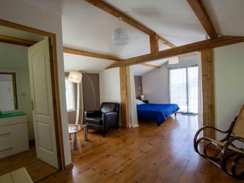 ein Schlafzimmer mit einem Bett und einem Stuhl in einem Zimmer in der Unterkunft Gîte Naussannes, 2 pièces, 2 personnes - FR-1-616-194 in Naussannes
