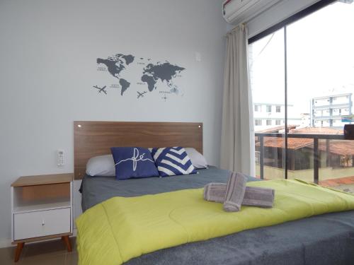 a bedroom with a bed with a yellow blanket at Varandas da Praia do Forte - Apartamento frente ao Mar in Cabo Frio