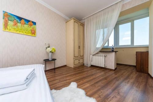 キーウにあるApartments with crazy panoramic view of the Dnieprのベッドと大きな窓のある寝室