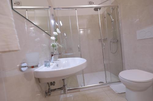 a bathroom with a shower and a sink and a toilet at Hotel Magna Grecia in Leuca