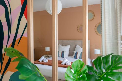ein Schlafzimmer mit einem Spiegel und einem Bett in der Unterkunft Travel Homes - Le Freedom, chaleureux & spacieux in Mulhouse