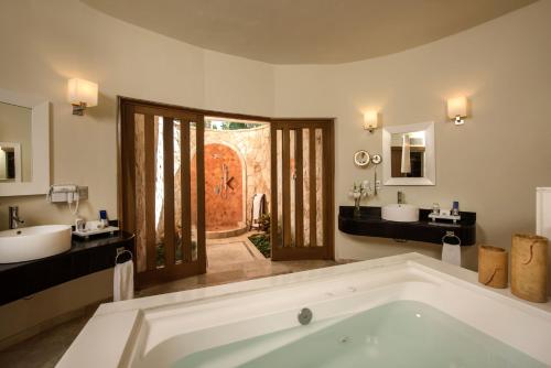 a large bathroom with two sinks and a tub at Grand Sunset Princess - All Inclusive in Playa del Carmen