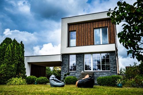 a house with two bean bags in front of it at Vila Smiltynė ant ežero kranto in Kuodžiai