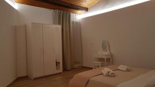 a white bedroom with a bed and a mirror at Il Centro Storico in Grottole