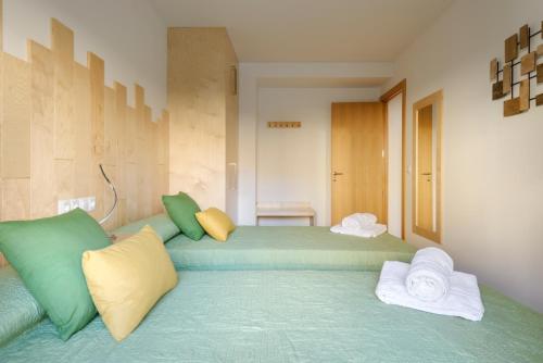 1 dormitorio con 2 camas con almohadas verdes y amarillas en OTAL URBAN de "Casa Otal", en Jaca
