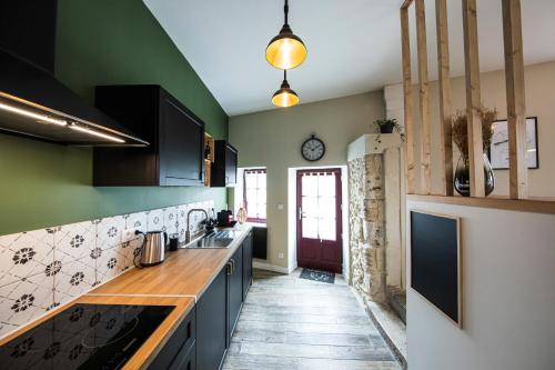 una cocina con paredes verdes y encimeras de madera en L'Atypique, charmante maison avec jardin clos en Amboise