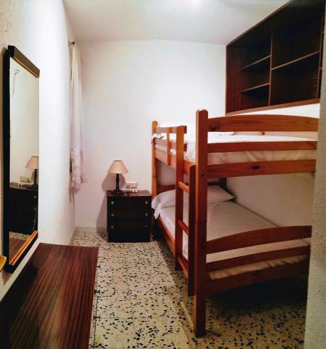 a bedroom with two bunk beds and a mirror at Cal PAU DE LA GRALLA in Pobla de Montornés
