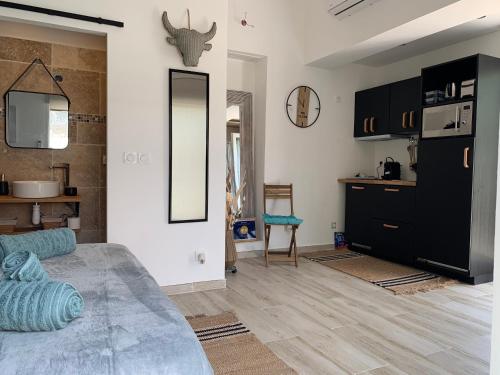 a living room with a bed and a mirror at L’olivier De Manel in Aigues-Mortes