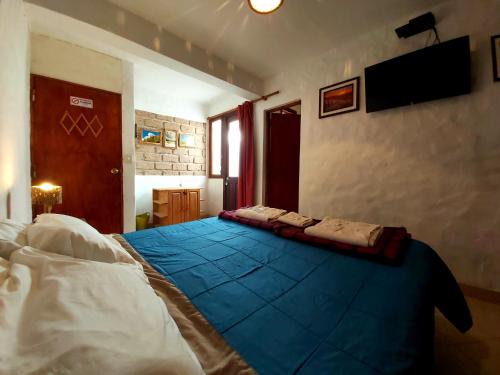 - une chambre avec un lit doté d'une couverture bleue dans l'établissement Hosteria Maimará, à Maimará