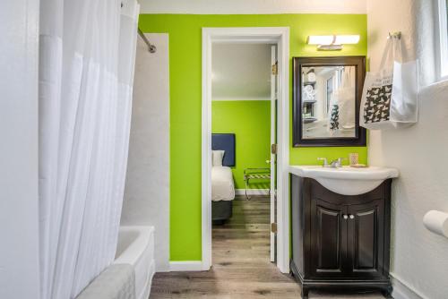a bathroom with a sink and a green wall at Signature Inn Eugene in Eugene
