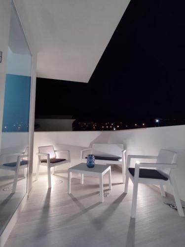 a white room with white chairs and a table at White Wall luxury rooms Scala dei turchi in Realmonte