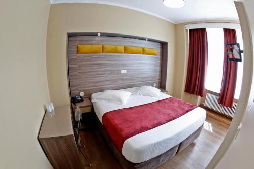 a bedroom with a large bed and a mirror at Hotel de France in Brussels