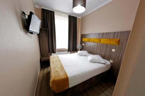 a hotel room with a bed and a television at Hotel de France in Brussels